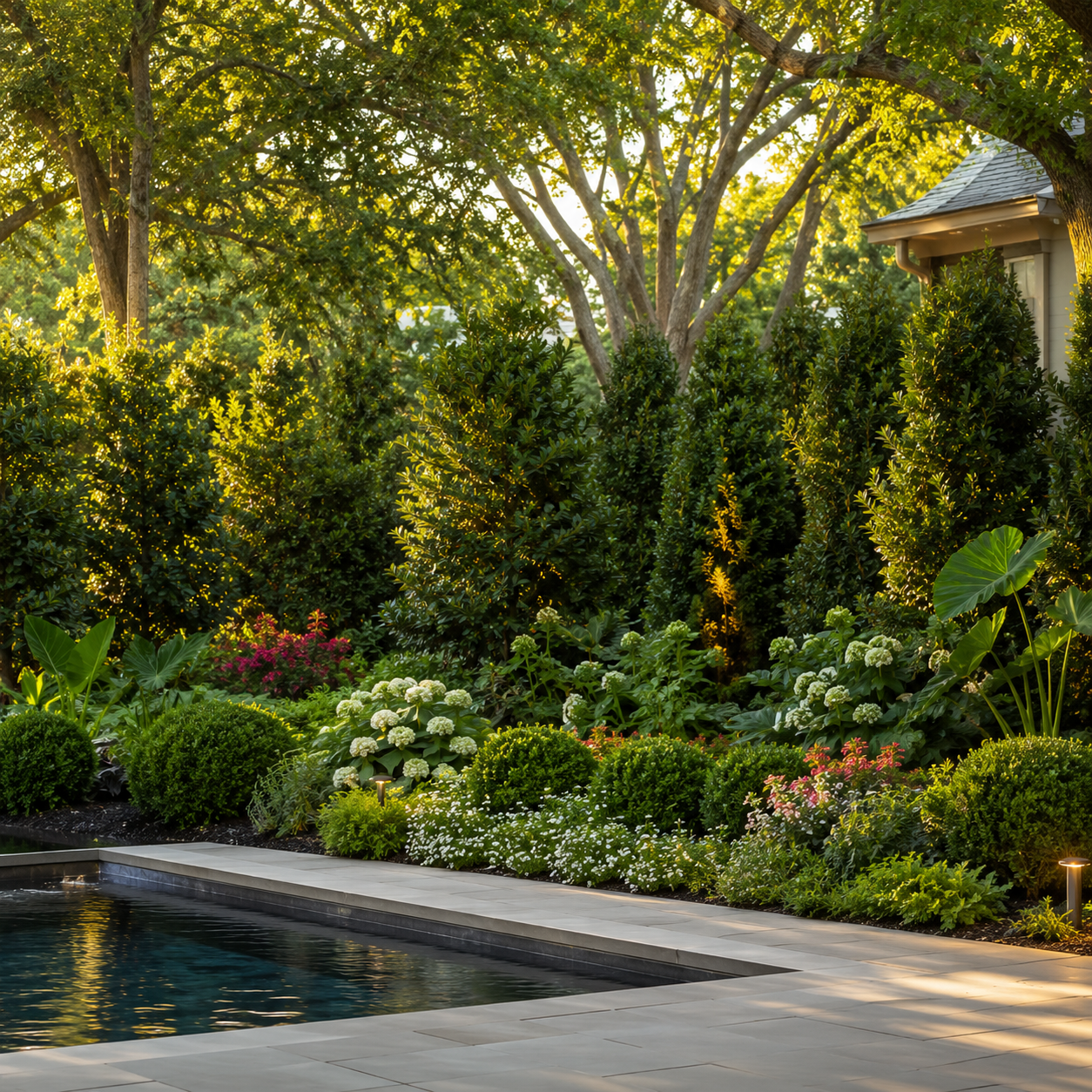 Layered privacy landscaping with mature trees, shrubs, and lush planting beds in a luxury Houston backyard